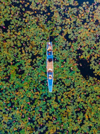 Foto de Couple in a wooden boat at the Beautiful Red Lotus Sea Kumphawapi is full of pink flowers in Udon Thani in northern Thailand. Flora of Southeast Asia. - Imagen libre de derechos