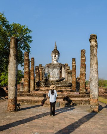 Foto de Mujeres asiáticas con sombrero visitan Wat Mahathat, ciudad vieja de Sukhothai, Tailandia. Antigua ciudad y cultura del sur de Asia Tailandia, parque histórico de Sukothai - Imagen libre de derechos