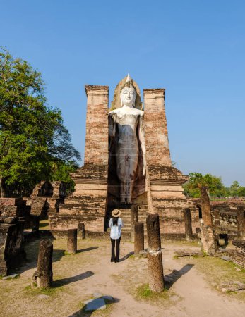 Photo for Asian women with a hat visit Wat Mahathat, Sukhothai old city, Thailand. Ancient city and culture of south Asia Thailand, Sukothai historical park - Royalty Free Image