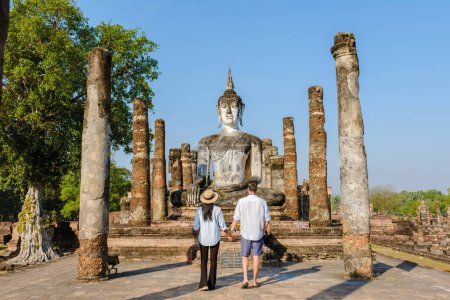 Foto de Un par de hombres y mujeres visitan Wat Mahathat, ciudad vieja de Sukhothai, Tailandia. Antigua ciudad y cultura del sur de Asia Tailandia, parque histórico de Sukothai - Imagen libre de derechos