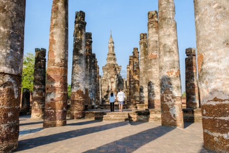 Photo for A Couple of men and women visit Wat Mahathat, Sukhothai old city, Thailand. Ancient city and culture of south Asia Thailand, Sukothai historical park - Royalty Free Image