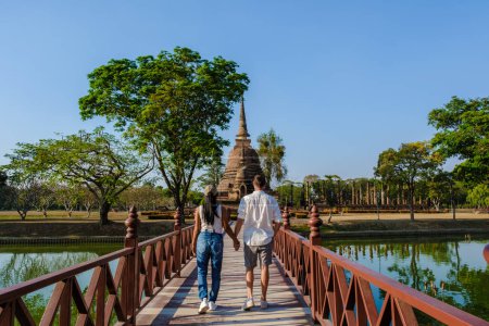 Téléchargez les photos : Quelques hommes et femmes visitent Wat Sa Sit, la vieille ville de Sukhothai, en Thaïlande. Ancienne ville et culture de l'Asie du Sud Thaïlande, parc historique de Sukothai - en image libre de droit