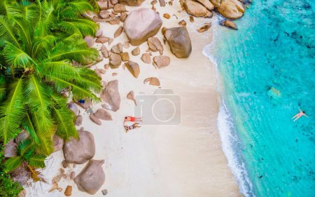 Foto de Drone view from above at Anse Lazio beach Praslin Island Seychelles. a couple of men and women on the beach - Imagen libre de derechos