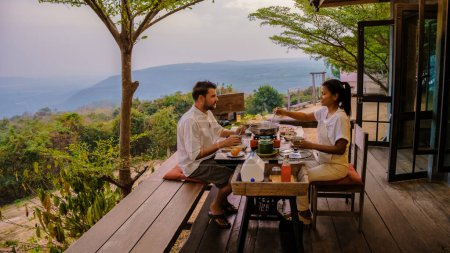 Photo for Thai Barbecue Buffet in the mountains on a tented camp, Thai style Grilled Sliced pork Thai Barbeque. couple having dinner outside - Royalty Free Image