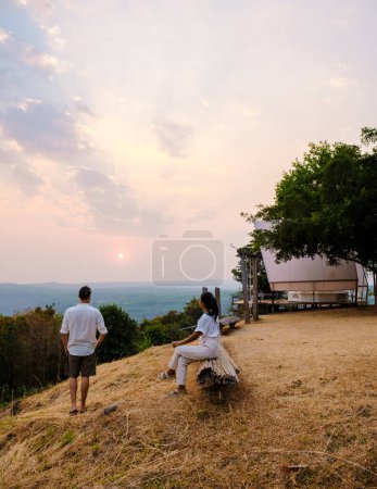 Photo for A couple of men and women watching the sunset at a mountain camping in Phitsanulok Thailand. luxury glamping - Royalty Free Image