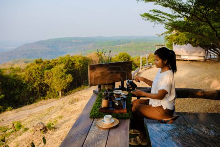 Téléchargez les photos : Femmes faisant du café goutte à goutte dans les montagnes de Thaïlande. Femme asiatique préparant le café sur un camp de tentes - en image libre de droit