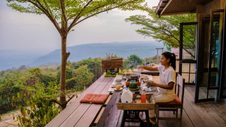 Photo for Thai Barbecue Buffet in the mountains on a tented camp, Thai style Grilled Sliced pork Thai Barbeque. Women having dinner in the mountains - Royalty Free Image