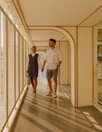 Téléchargez les photos : Couple en vacances dans un hôtel de luxe art déco architecture des années 80 hommes et femmes en voyage en ville - en image libre de droit