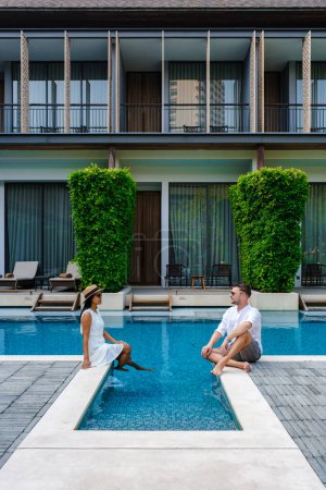 Foto de Hotel de lujo de 5 estrellas con piscina en Asia. Un par de hombres y mujeres de vacaciones en un hotel de lujo, hombres y mujeres junto a la piscina - Imagen libre de derechos