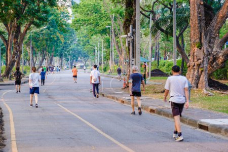 Téléchargez les photos : Lumpini parc Bangkok Thaïlande Mars 2023, les gens qui courent dans le parc avec un ciel pollué par l'air pm 2,5 smog - en image libre de droit