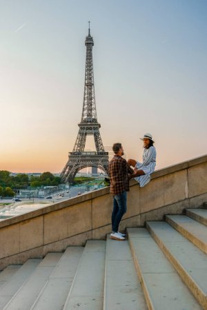 Téléchargez les photos : Jeune couple par Tour Eiffel à Sunrise, Paris Tour Eifel Sunrise homme femme amoureuse, concept valentin à Paris la ville de l'amour. Hommes et femmes visitant la tour Eiffel. - en image libre de droit