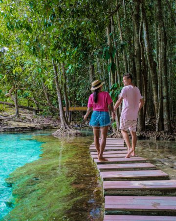 Téléchargez les photos : Un couple visite la piscine d'émeraude et la piscine bleue à Krabi en Thaïlande, la piscine d'émeraude et la piscine bleue, les arbres et les mangroves avec de l'eau cristalline Province de Krabi, Thaïlande. - en image libre de droit