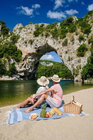 Téléchargez les photos : Couple pique-nique sur la plage en vacances en Ardèche France Pont d'Arc, Ardèche France, vue sur l'arche naturelle à Vallon Pont dArc dans le canyon d'Ardèche en France Europe Rhône Alpes Dordogne - en image libre de droit