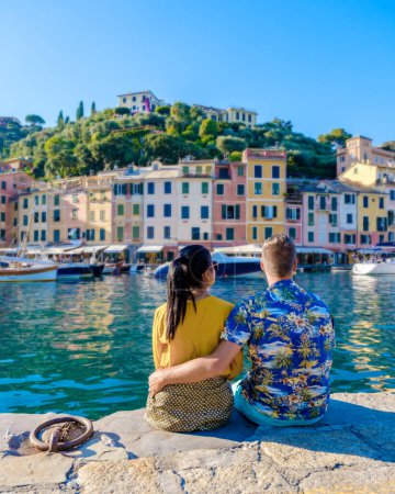 Photo for Couple mid age man and women visiting Italy during a vacation in the summer, Beautiful sea coast with colorful houses in Portofino, Italy Europe Portofino in Liguria, Italy. Genoa - Royalty Free Image