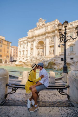 Foto de Hombres y mujeres turistas en la Fontana de Trevi, Roma, Italia. Viaje a Roma pareja en un viaje por la ciudad en Roma. - Imagen libre de derechos