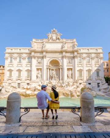 Foto de Hombres y mujeres turistas en la Fontana de Trevi, Roma, Italia. Viaje a Roma pareja en un viaje a Roma durante las vacaciones de verano - Imagen libre de derechos