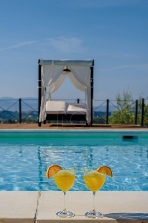 Téléchargez les photos : Villa de luxe avec piscine en Italie. Piscine et ancienne ferme au coucher du soleil dans le centre de l'Italie. Couple en vacances dans une villa de luxe en Italie, hommes et femmes regardant le coucher du soleil. - en image libre de droit