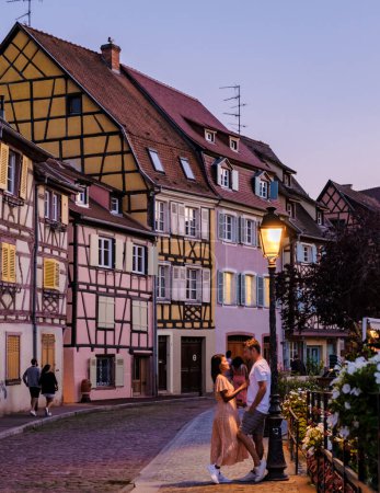Photo for Couple of men and women on a city trip at Colmar France Beautiful view of the colorful romantic city of Colmar in the evening, the Historic town of Colmar, Alsace region, France - Royalty Free Image