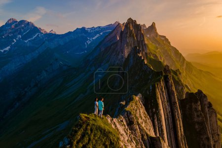 Foto de La cordillera de Schaeffler suiza Alpstein, Appenzell Suiza, cresta del majestuoso pico Schaeffler de Berggasthaus Schafler, Suiza. pareja de hombres y mujeres en las montañas durante la puesta del sol - Imagen libre de derechos