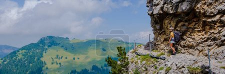 Téléchargez les photos : Femmes asiatiques marchant dans les Alpes suisses pendant les vacances d'été avec un sac à dos et des bottes de randonnée. femme marchant sur le sentier Saxer Lucke - en image libre de droit