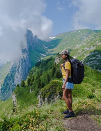 Téléchargez les photos : Randonnées pédestres dans les Alpes suisses pendant les vacances d'été avec un sac à dos et des bottes de randonnée. femme marchant sur le sentier Saxer Lucke - en image libre de droit