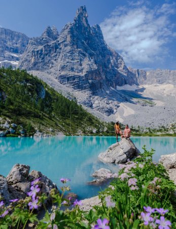 Téléchargez les photos : Couple d'hommes et de femmes visitant Lago di Sorapis dans les Dolomites italiennes, lac bleu laiteux Lago di Sorapis, lac Sorapis, Dolomites, Italie. - en image libre de droit