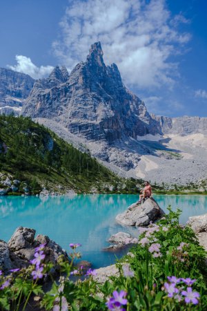 Téléchargez les photos : Hommes visitant Lago di Sorapis dans les Dolomites italiennes, lac bleu laiteux Lago di Sorapis, lac Sorapis, Dolomites, Italie. - en image libre de droit