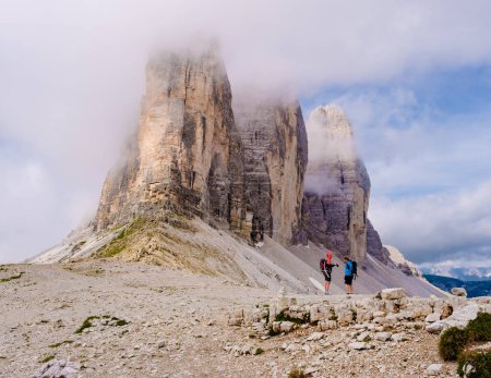 Photo for Tre Cime di Lavaredo peaks or Drei Zinnen at sunset, Dobbiaco Toblach, Trentino -Alto Adige or South Tyrol, Italy. Europe Alps. A couple of man and woman hiking in the Dolomites July 2021 - Royalty Free Image
