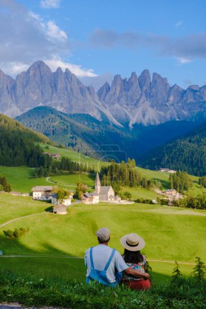 Couple viewing the landscape of Santa Maddalena Village Val di Funes, South Tyrol, Italy Dolomites, men and women visit Dolomites mountains, Val di Funes valley, Trentino Alto Adige, South Tyrol