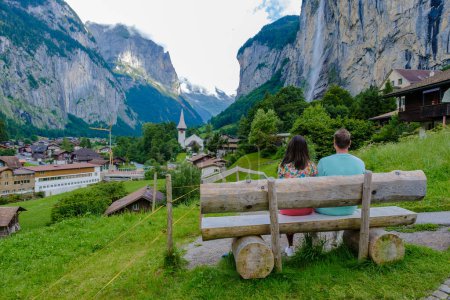 Foto de Pareja que visita el valle de Lauterbrunnen con una hermosa cascada y los Alpes suizos en el fondo, Berner Oberland, Suiza, Europa. - Imagen libre de derechos