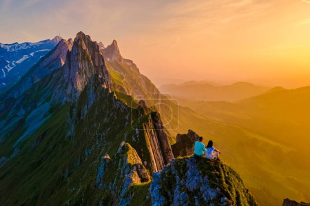 Foto de La cordillera de Schaeffler suiza Alpstein, Appenzell Suiza, cresta del majestuoso pico Schaeffler de Berggasthaus Schafler, Suiza. pareja de hombres y mujeres en las montañas durante la puesta del sol - Imagen libre de derechos