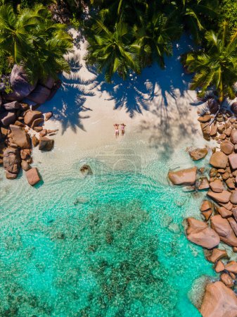 Foto de Praslin Seychelles isla tropical con playas y palmeras, pareja de hombres y mujeres de mediana edad de vacaciones en Seychelles visitando la playa tropical Anse Lazio Praslin Seychelles. vista del dron - Imagen libre de derechos
