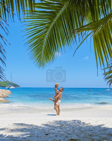 Téléchargez les photos : Anse Lazio Praslin Seychelles, un jeune couple d'hommes et de femmes sur une plage tropicale pendant des vacances de luxe aux Seychelles. Plage tropicale Anse Lazio Praslin Seychelles - en image libre de droit