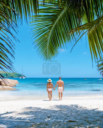 Photo for Praslin Seychelles tropical island with withe beaches and palm trees, couple of men and women mid age on vacation at Seychelles visiting the tropical beach Anse Lazio Praslin Seychelles. drone view - Royalty Free Image