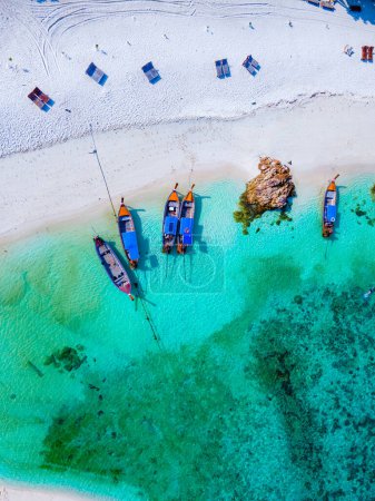 Photo for Drone view at the beach of Koh Kradan island in Thailand, with a couple of men and women walking on the beach of sunset beach - Royalty Free Image