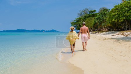 Photo for A couple of men and woman on the beach of Koh Kradan Island Thailand, men and women relaxing on the beach with a turqouse colored ocean - Royalty Free Image