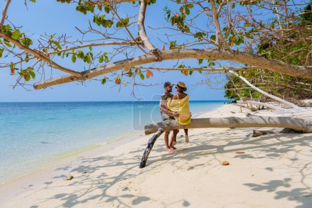 Photo for A couple of men and woman on the beach of Koh Kradan Island Thailand, men and women relaxing on the beach with a turqouse colored ocean on a sunny day - Royalty Free Image