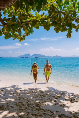 Foto de Un par de hombres y mujeres caminando en la playa de la isla de Koh Kradan en Tailandia durante las vacaciones en un día soleado - Imagen libre de derechos