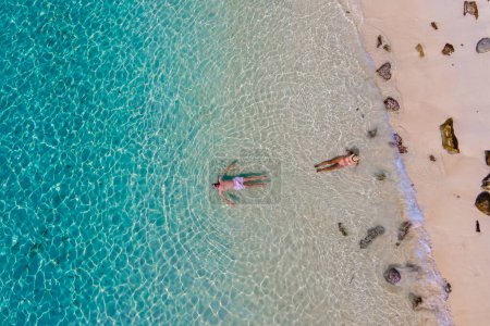 Téléchargez les photos : Vue par drone d'un homme et d'une femme nageant dans l'océan bleu turqouse de l'île de Koh Kradan en Thaïlande - en image libre de droit