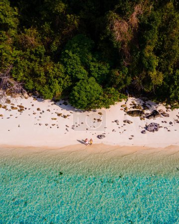 Téléchargez les photos : Vue de drone à la plage de l'île de Koh Kradan en Thaïlande, vue aérienne sur l'île de Koh Kradan Trang, couple d'hommes et de femmes sur la plage pendant les vacances en Thaïlande - en image libre de droit