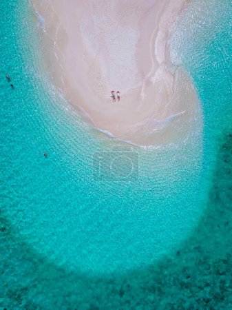 Téléchargez les photos : Un couple d'hommes et de femmes sur un banc de sable blanc dans l'océan de Koh Lipe Island sud de la Thaïlande, avec turqouse couleur océan et sable blanc plage de sable à Ko Lipe par une journée ensoleillée - en image libre de droit