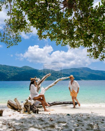 Téléchargez les photos : Un homme et une femme se détendre sur la plage de Koh Lipe Island sud de la Thaïlande avec turqouse couleur océan et plage de sable blanc à Ko Lipe. Parc national de Tarutao, île de Koh Rawi - en image libre de droit
