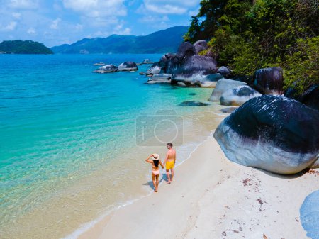 Photo for Couple of men and women on the beach in swimwear at Koh Adang Island near Koh Lipe Island Southern Thailand with turqouse colored ocean and white sandy beach Tarutao National Park - Royalty Free Image