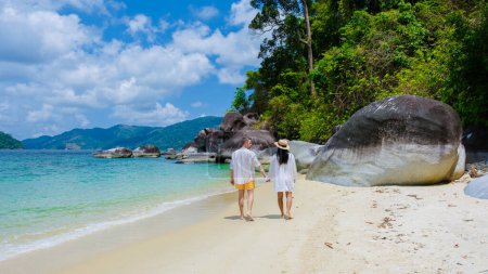 couple on beach in swimwear at Koh Adang Island near Koh Lipe Island Southern Thailand with turqouse colored ocean and white sandy beach Tarutao National Park