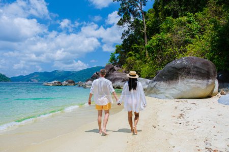 Téléchargez les photos : Couple d'hommes et de femmes sur la plage en maillots de bain à l'île de Koh Adang près de l'île de Koh Lipe en Thaïlande du Sud avec turqouse couleur océan et plage de sable blanc Tarutao National Park - en image libre de droit