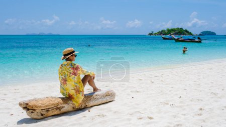 Téléchargez les photos : Koh Lipe Island Sud de la Thaïlande avec turqouse couleur océan et plage de sable blanc à Ko Lipe. une femme asiatique thaïlandaise en vacances en Thaïlande se détendre à la plage en regardant l'océan - en image libre de droit