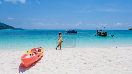Photo for Koh Lipe Island Southern Thailand with turqouse colored ocean and white sandy beach at Ko Lipe. a Asian Thai woman on vacation in Thailand relaxing at the beach looking at the ocean - Royalty Free Image