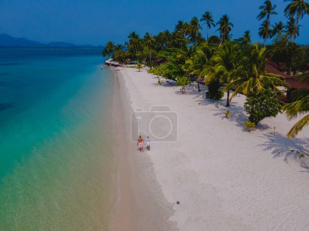 Téléchargez les photos : Un couple d'hommes et de femmes en vacances à Koh Mook île tropicale dans la mer d'Andaman en Thaïlande - en image libre de droit