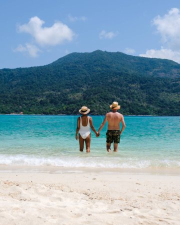 Foto de Pareja de hombres y mujeres en la playa de Koh Lipe Island Tailandia, una isla tropical con un océano azul y arena blanca y suave. Ko Lipe Island Tailandia - Imagen libre de derechos