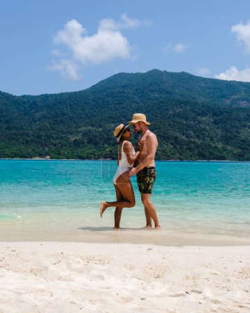 Téléchargez les photos : Couple sur la plage de Koh Lipe Island Thaïlande, une île tropicale avec un océan bleu et sable blanc doux. Ko Lipe Island Thaïlande par une journée ensoleillée - en image libre de droit